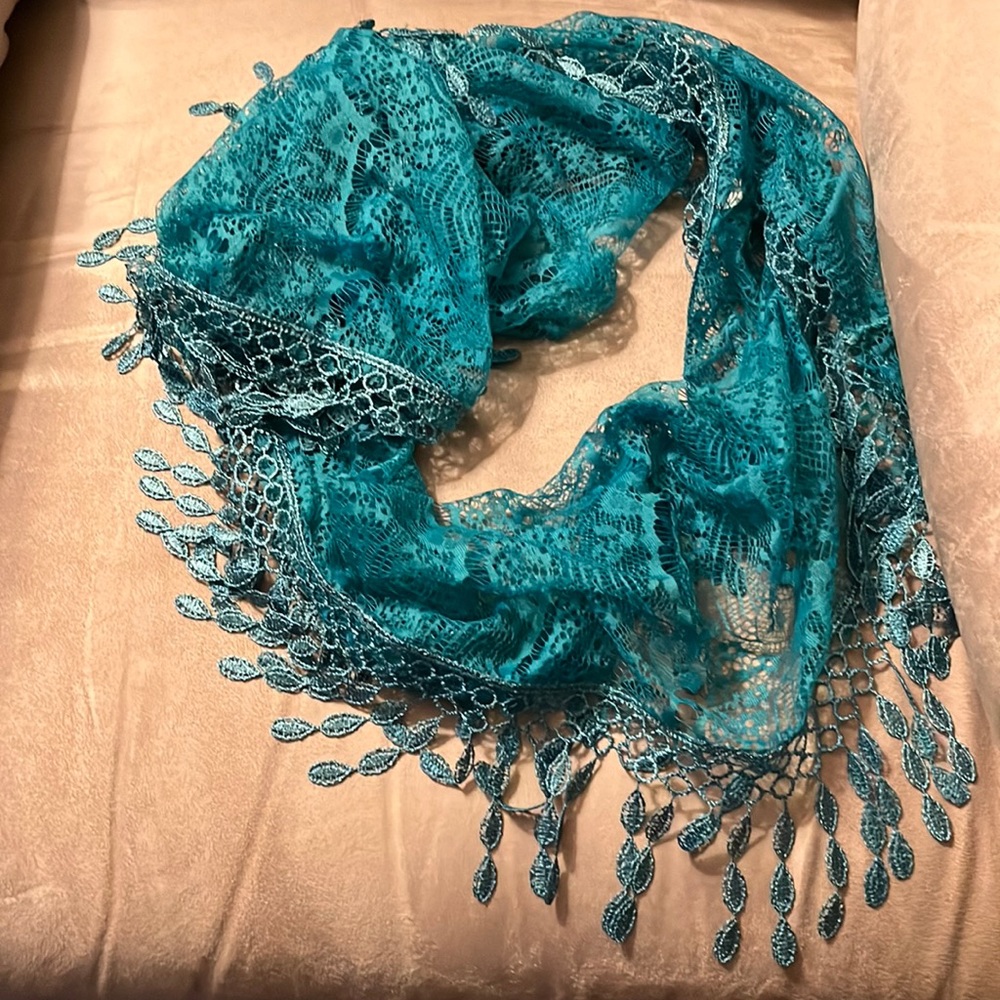 Turquoise circular scarf with fringe.